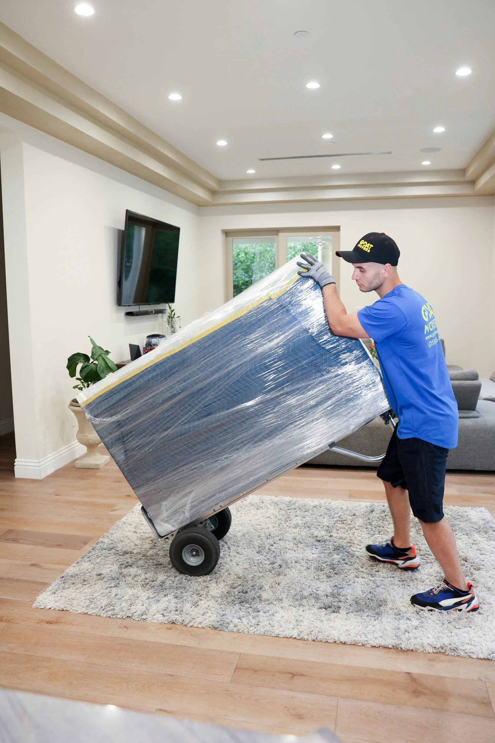 Mover carrying wrapped furniture