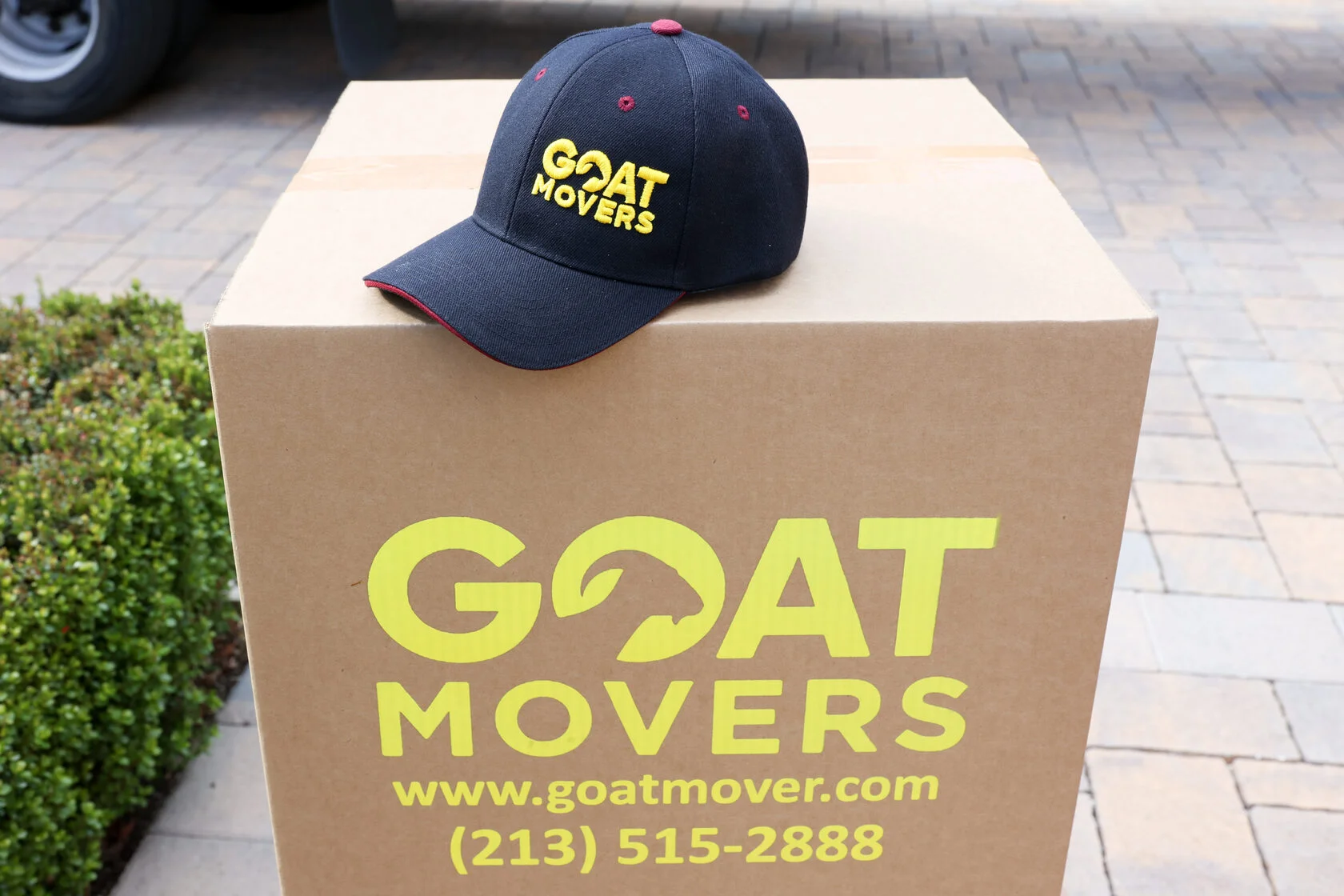 GOAT Movers branded cap and box